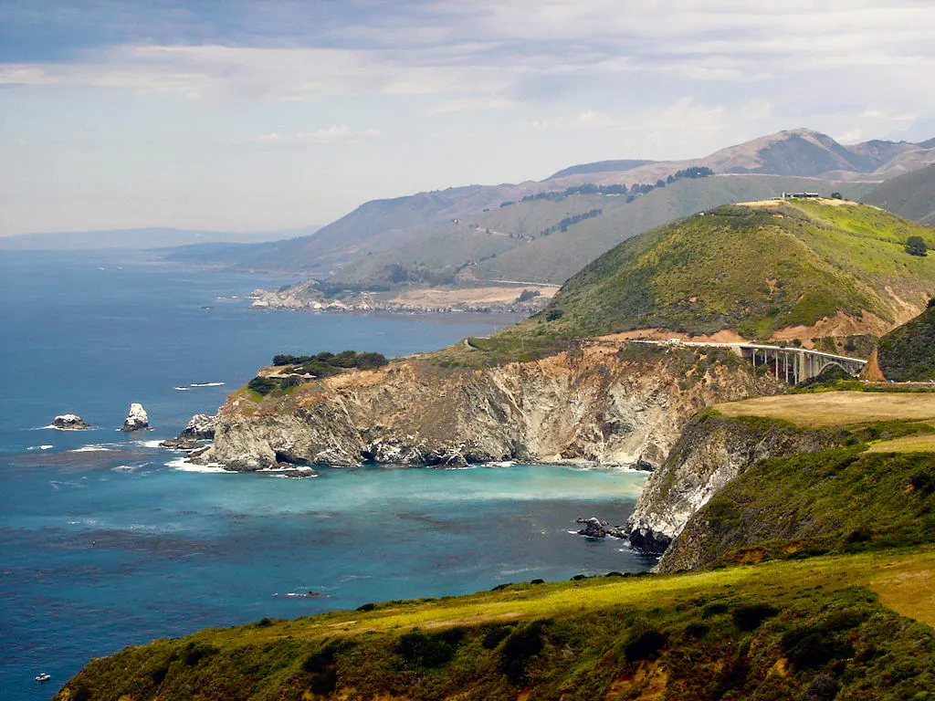 Kliffen van de Big Sur-kust met de Bixby Creek Bridge, groene heuvels en blauwe oceaan
