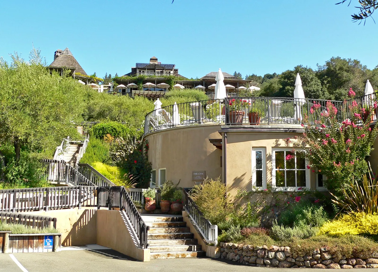 Terrassen en trappen van Auberge du Soleil op een heuvel in Napa Valley, met parasols en bloeiende tuinen