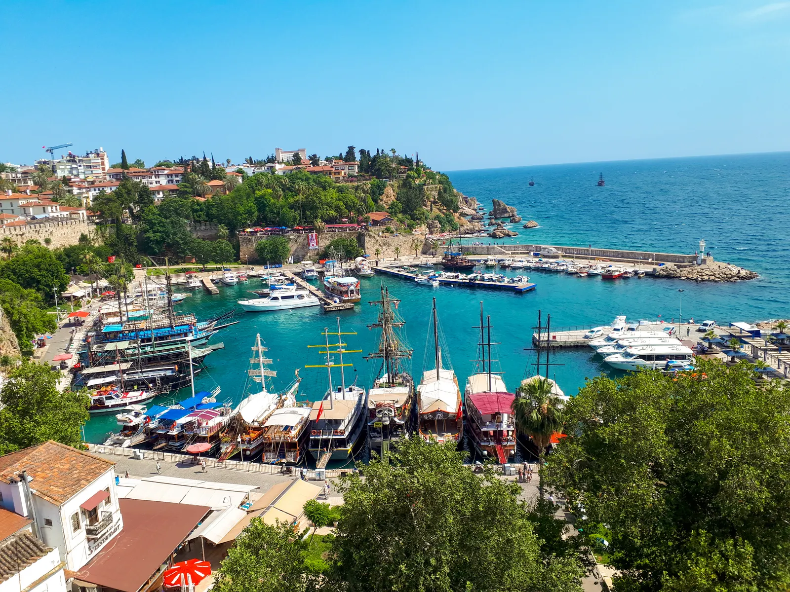 Uitzicht op de oude haven van Kaleiçi in Antalya met houten zeilschepen, jachten en turquoise zee