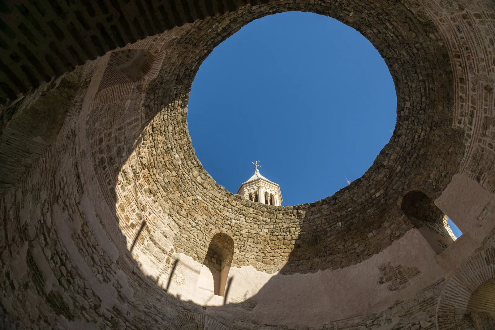 Blik omhoog door de ronde opening van het Vestibulum in het Paleis van Diocletianus met de klokkentoren